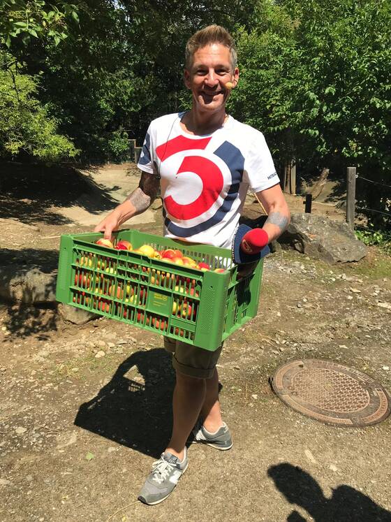Andi Knoll mit einem Korb Äpfel in der Tierwelt Herberstein